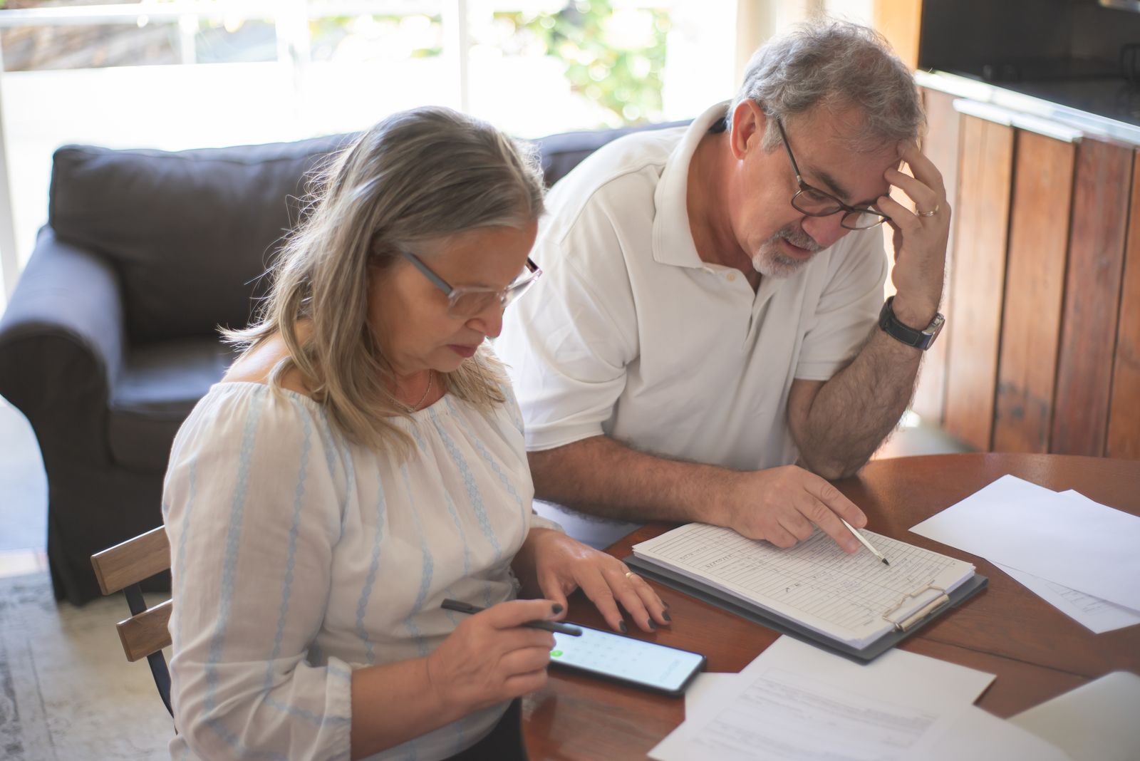 Un couple revoit ensemble des papiers du foyer, à la maison.
